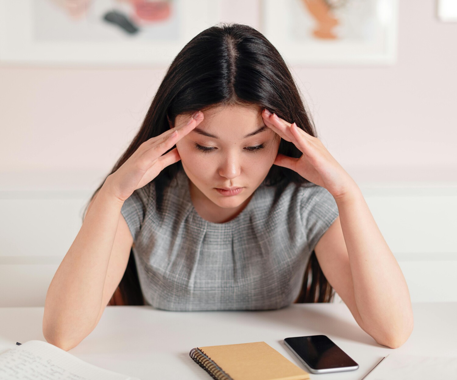 Femme stressée avec son cahier et son téléphone sur la table