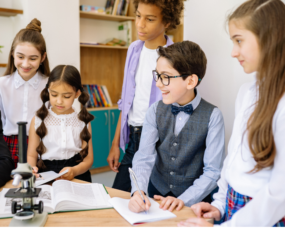 Photo d'un groupe d'élèves à l'école. Ils sont en train de faire un cours de sciences avec un microscope. Ils sont concentrés et deux élèves prennent des notes.